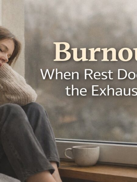Person resting by a window showing quiet burnout, appearing functional but deeply exhausted